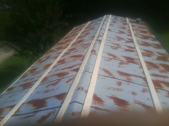 Rusted metal roof panels with new wood purlins before replacement — Storm Damage Roof Repair in Hiawatha by Roofing Brothers