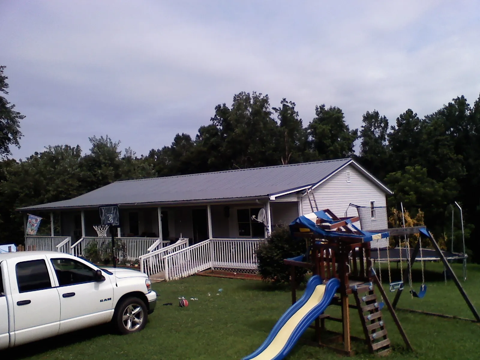 Dark metal roof on a country home with a full length front porch in Hiawatha